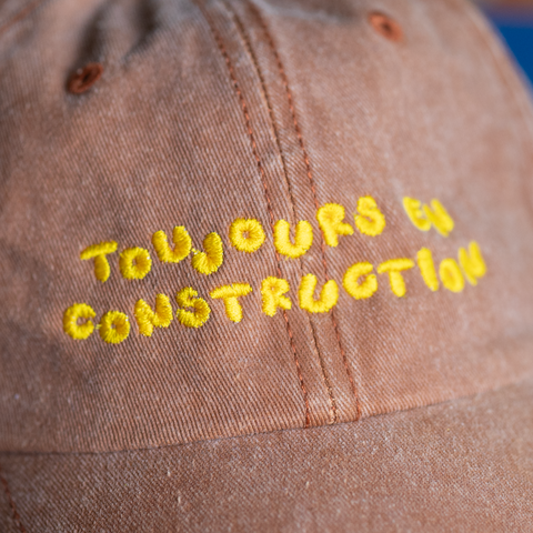 'toujours en construction' brown hat