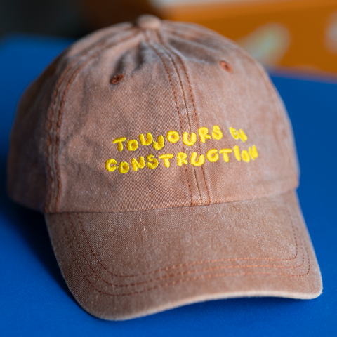 'toujours en construction' brown hat
